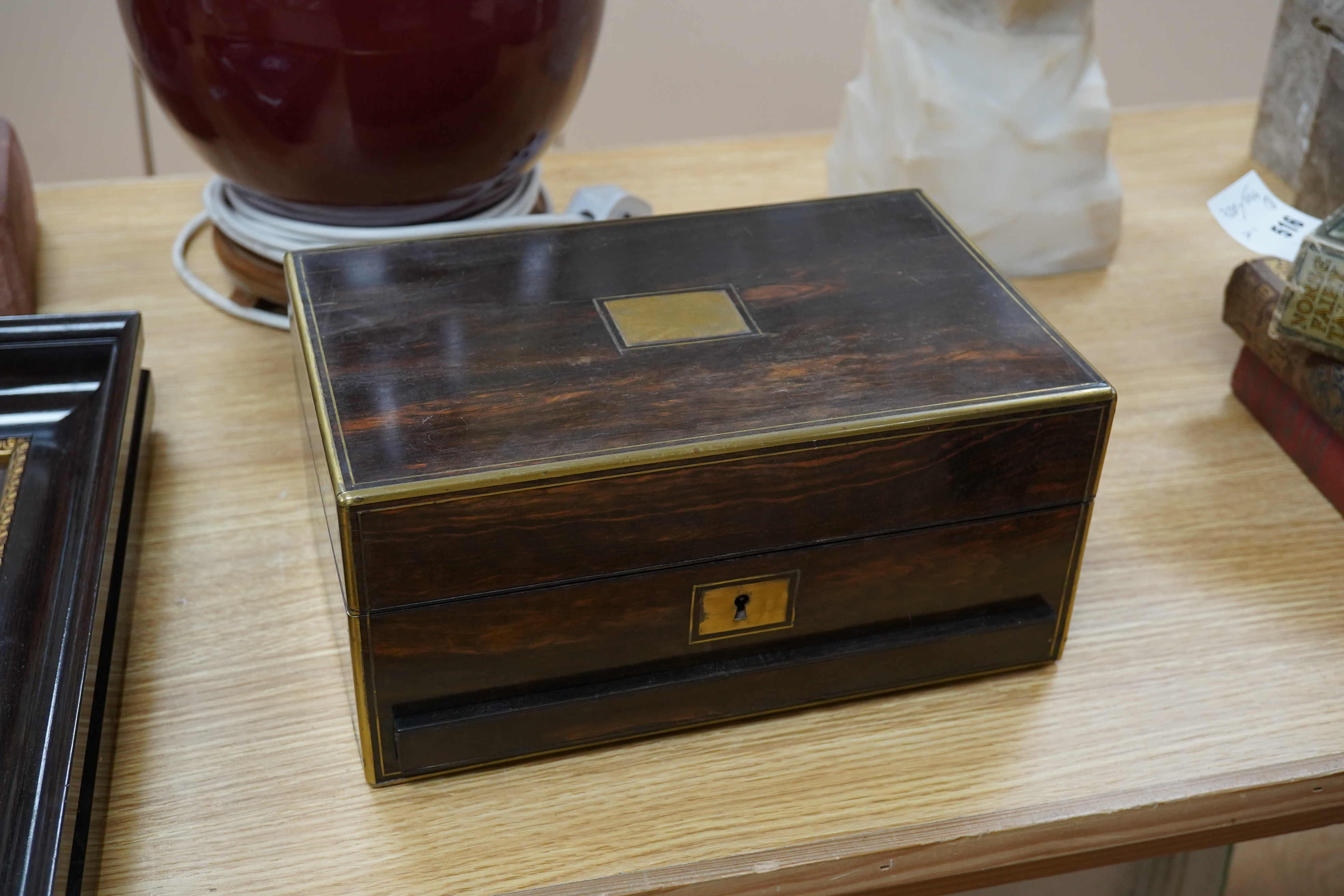 A Victorian brass bound coromandel wood jewellery casket, with velvet lined lid, a fitted leather and velvet top compartment shelf and base lower drawer. 13cm high x 28cm wide. Condition - some splits to the veneer on th